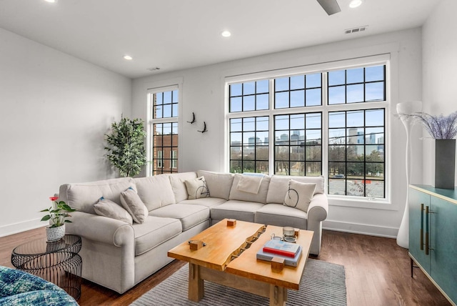 living area with baseboards, visible vents, dark wood-style flooring, and recessed lighting