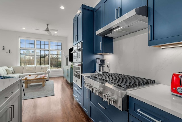 kitchen with stainless steel gas cooktop, light countertops, blue cabinetry, and under cabinet range hood