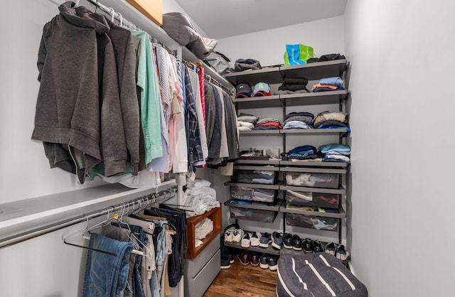 walk in closet with wood finished floors