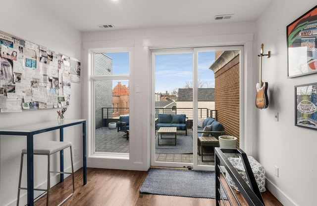 entryway with baseboards, visible vents, and wood finished floors