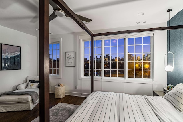 bedroom with a ceiling fan, a view of city, baseboards, and wood finished floors