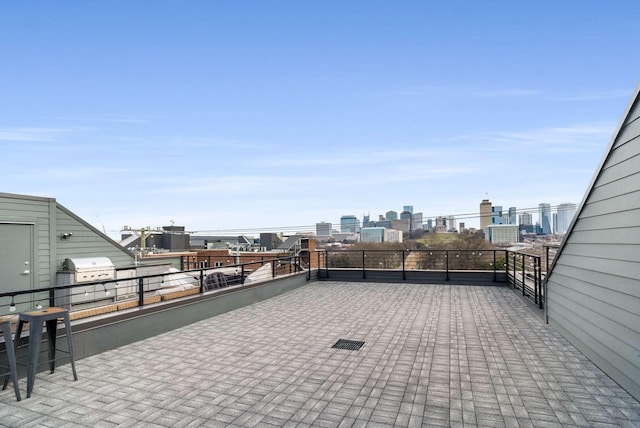 view of patio / terrace with a city view, grilling area, and a balcony