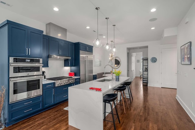 kitchen featuring under cabinet range hood, blue cabinets, stainless steel appliances, a sink, and visible vents