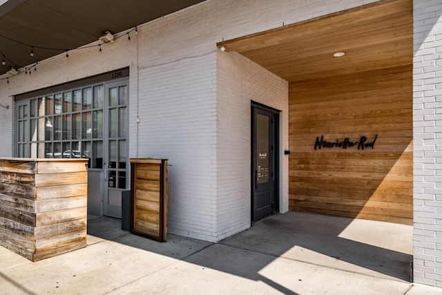 doorway to property featuring brick siding