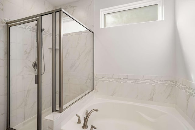 bathroom featuring a garden tub and a shower stall