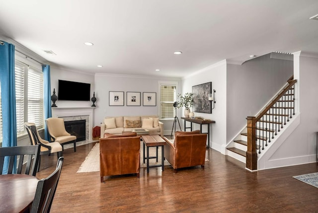 living area with stairway, ornamental molding, a high end fireplace, wood finished floors, and baseboards