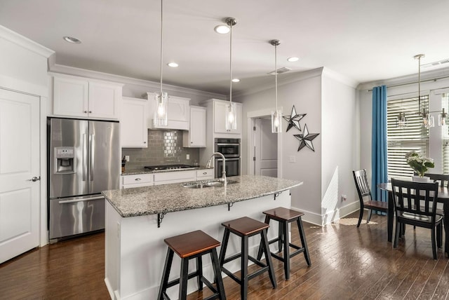 kitchen with stainless steel appliances, a sink, ornamental molding, dark wood-style floors, and tasteful backsplash