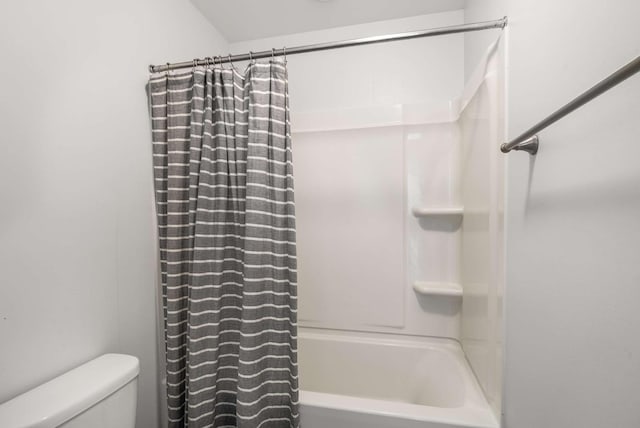 bathroom featuring shower / bath combo and toilet