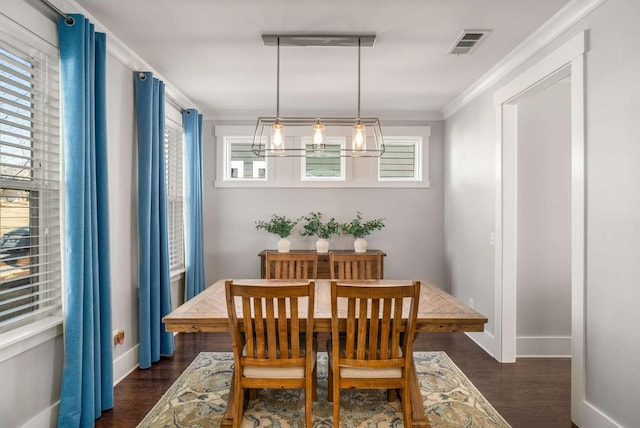 dining area with ornamental molding, dark wood-type flooring, visible vents, and baseboards