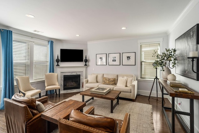 living room featuring crown molding, visible vents, a high end fireplace, wood finished floors, and baseboards