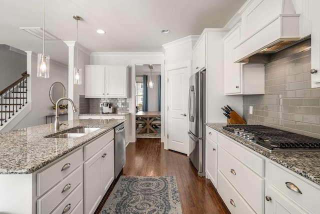 kitchen with stainless steel appliances, premium range hood, dark wood-type flooring, a sink, and white cabinetry