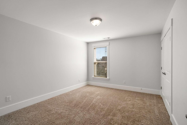 interior space featuring baseboards, visible vents, and light colored carpet