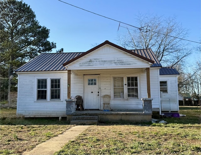 bungalow featuring a front yard, covered porch, and metal roof