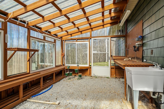 sunroom with lofted ceiling and a sink