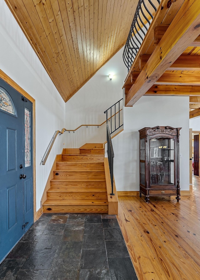 interior space featuring stairs, wood ceiling, high vaulted ceiling, baseboards, and hardwood / wood-style flooring