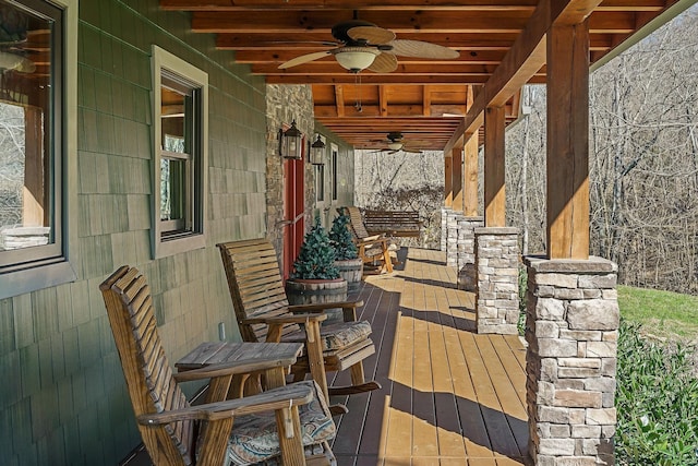 wooden terrace with a porch and ceiling fan