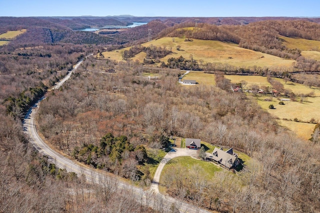 aerial view featuring a wooded view and a mountain view