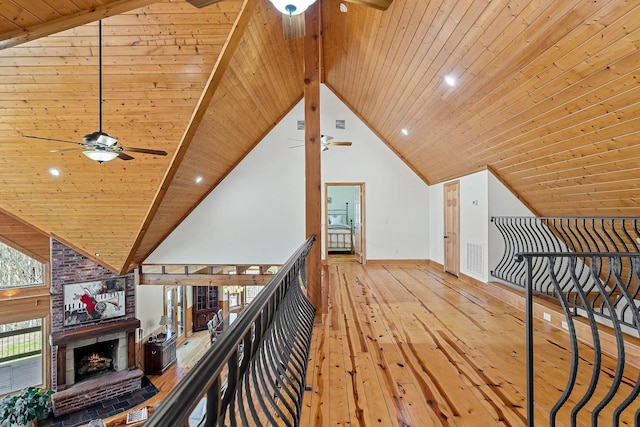 bonus room featuring high vaulted ceiling, a fireplace, wood-type flooring, and a ceiling fan