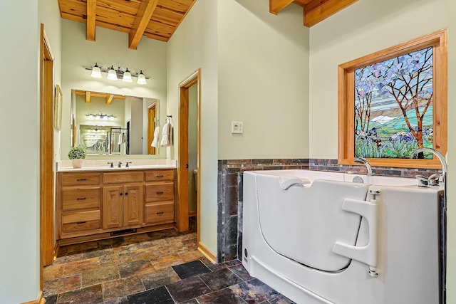 full bathroom featuring a bathing tub, stone finish flooring, vanity, wooden ceiling, and beamed ceiling