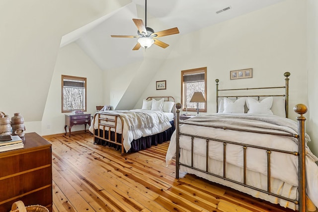 bedroom with baseboards, visible vents, a ceiling fan, vaulted ceiling, and light wood-type flooring