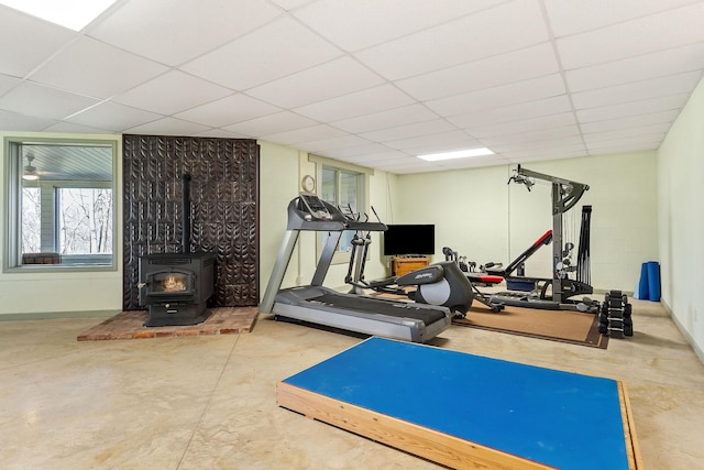 exercise area featuring a paneled ceiling and a wood stove