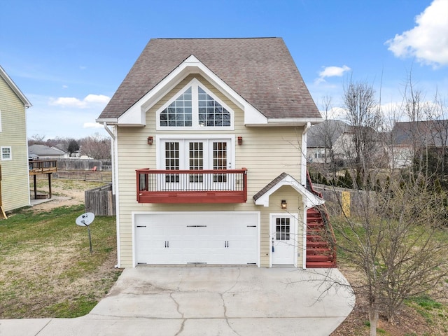 view of front facade featuring a shingled roof, a garage, driveway, and a front lawn