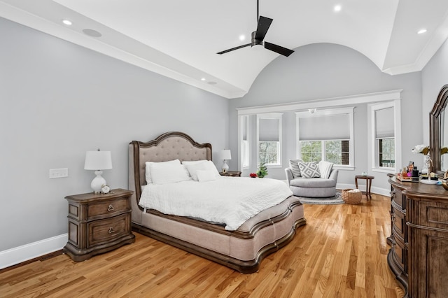 bedroom with lofted ceiling, light wood finished floors, and baseboards