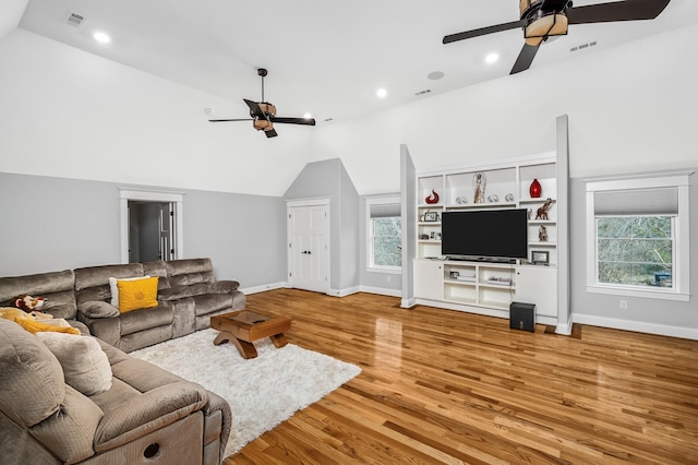 living area with ceiling fan, light wood finished floors, lofted ceiling, and visible vents