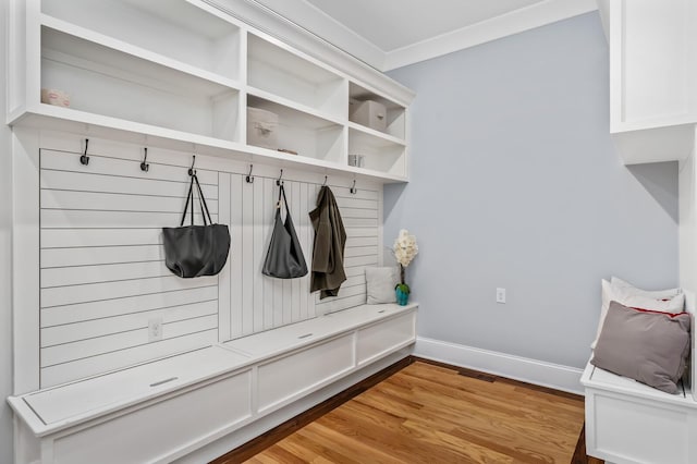 mudroom with ornamental molding, light wood-style flooring, and baseboards