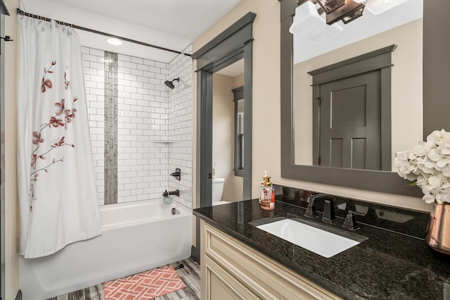 bathroom featuring toilet, shower / tub combo, and vanity