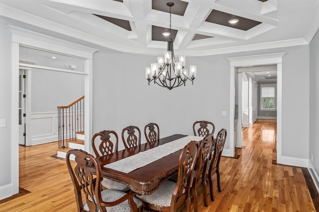 dining room with light wood finished floors, coffered ceiling, stairway, crown molding, and a chandelier