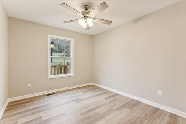 unfurnished room featuring light wood-style flooring, a ceiling fan, visible vents, and baseboards