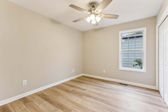 unfurnished bedroom with a closet, visible vents, ceiling fan, light wood-type flooring, and baseboards