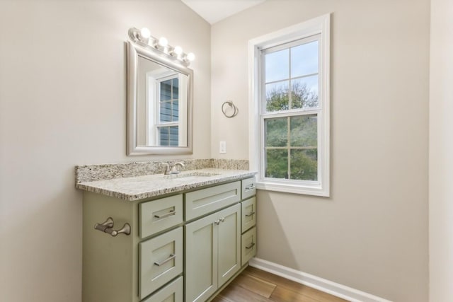 bathroom with baseboards, wood finished floors, and vanity