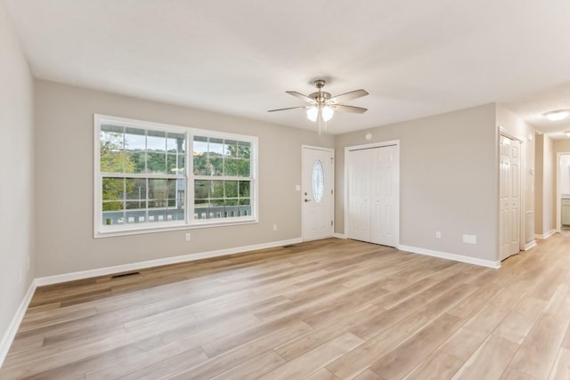 unfurnished room featuring ceiling fan, light wood-type flooring, visible vents, and baseboards