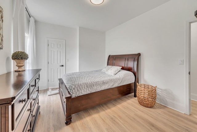 bedroom with light wood finished floors and baseboards