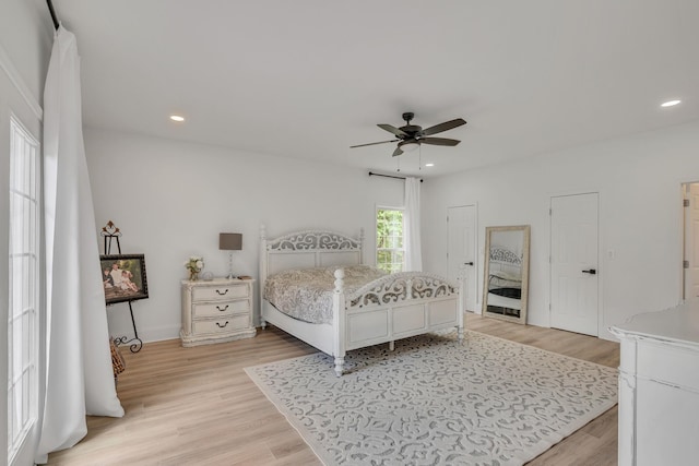 bedroom with two closets, light wood finished floors, a ceiling fan, and recessed lighting