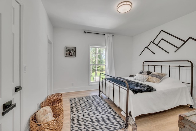 bedroom featuring light wood-style floors and baseboards