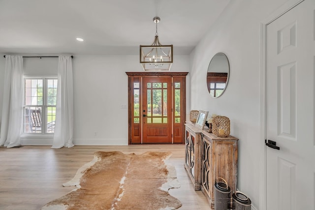 entryway with recessed lighting, baseboards, light wood finished floors, and an inviting chandelier