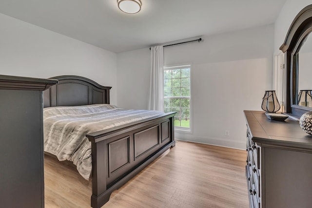 bedroom featuring light wood-style flooring and baseboards