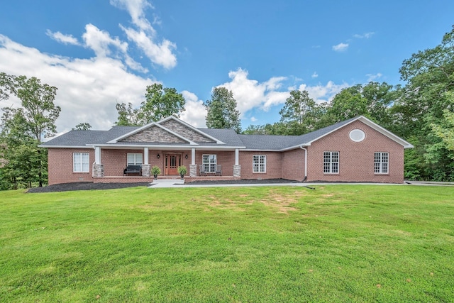 view of front facade featuring covered porch, a front lawn, and brick siding