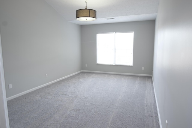 carpeted spare room with visible vents and baseboards