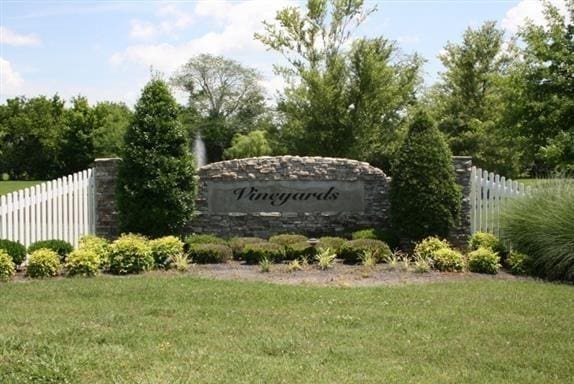 community sign featuring a yard and fence