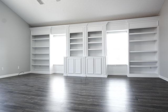 interior space with vaulted ceiling, dark wood finished floors, and baseboards