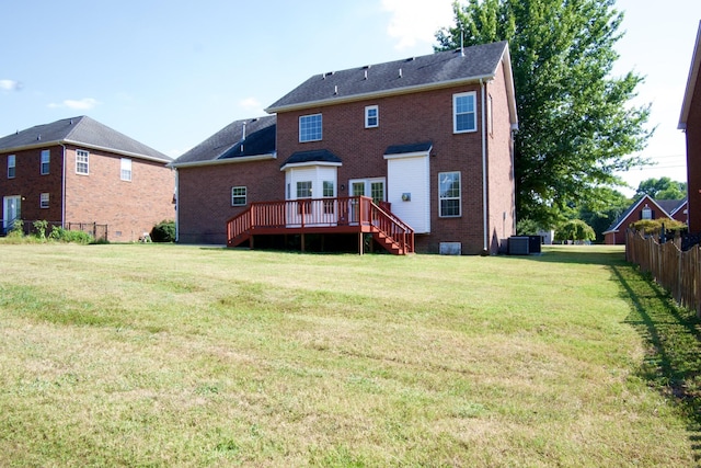 back of property with brick siding, a yard, a wooden deck, and central air condition unit