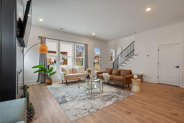 living room featuring recessed lighting, light wood-style flooring, baseboards, and stairs