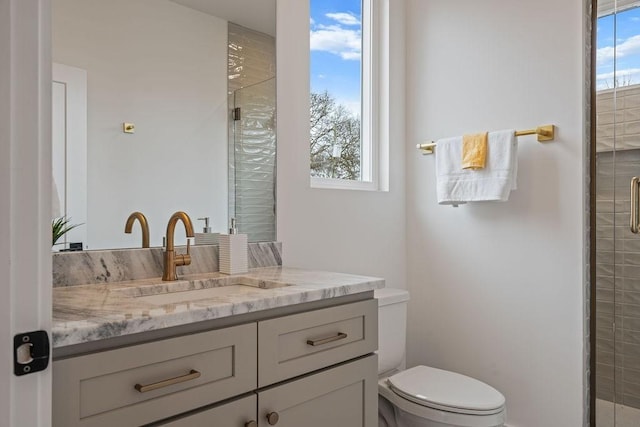 full bathroom featuring a stall shower, vanity, and toilet