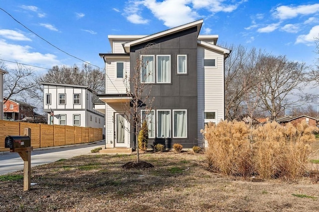 contemporary home featuring fence