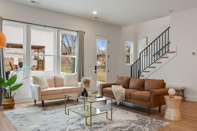 sitting room with recessed lighting, visible vents, wood finished floors, baseboards, and stairs