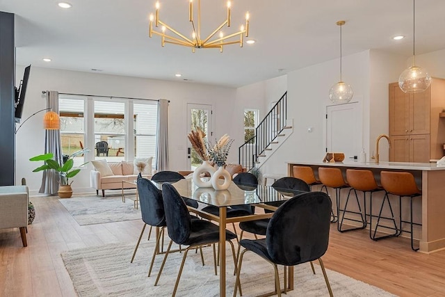 dining area with stairway, light wood-type flooring, and a healthy amount of sunlight